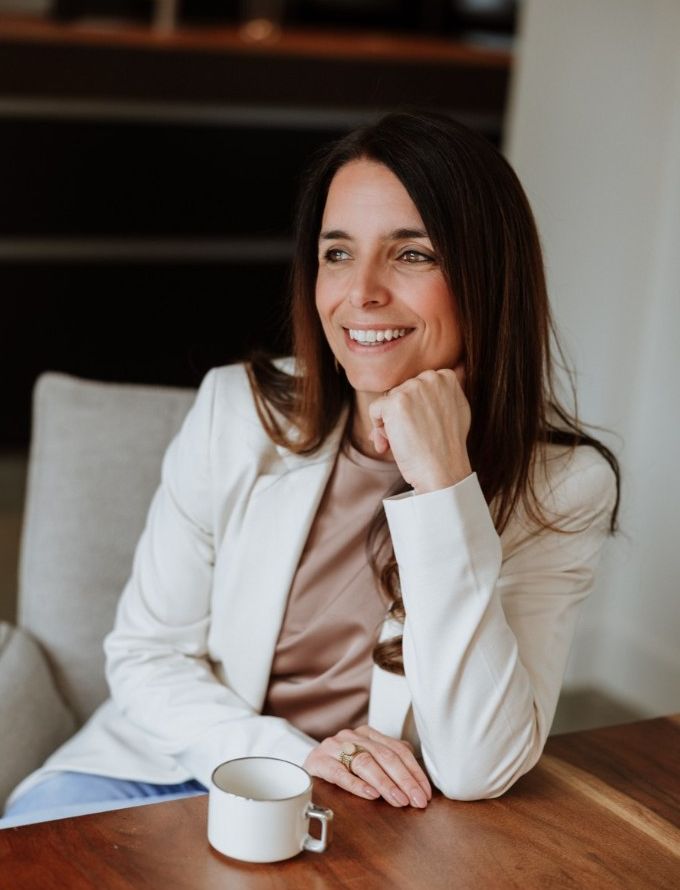 Joyce Schiffers aan tafel met een kop koffie, lachend